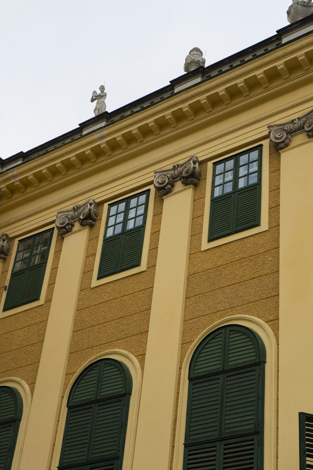 a building with green shutters and a clock