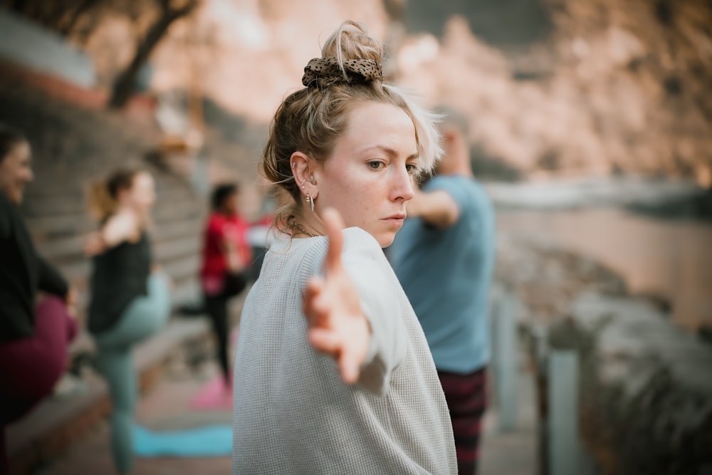 a woman pointing at something while others look on