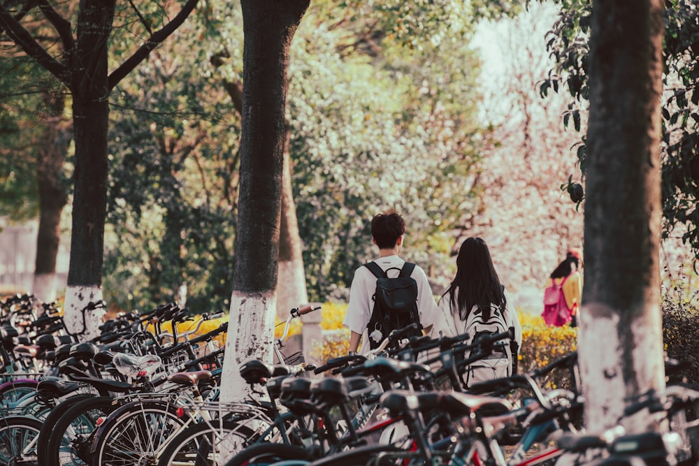 a group of people standing next to a bunch of bikes