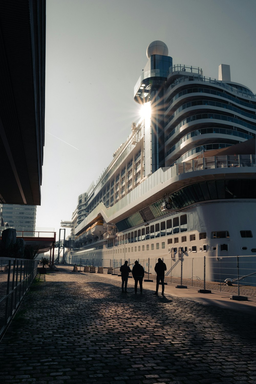 a group of people walking down a street next to a cruise ship