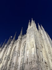 A shadowy cathedral silhouetted against a stormy twilight sky.