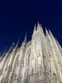A shadowy cathedral silhouetted against a stormy twilight sky.