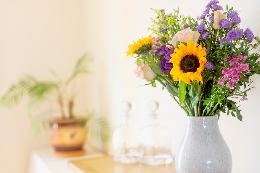 a vase filled with lots of different colored flowers