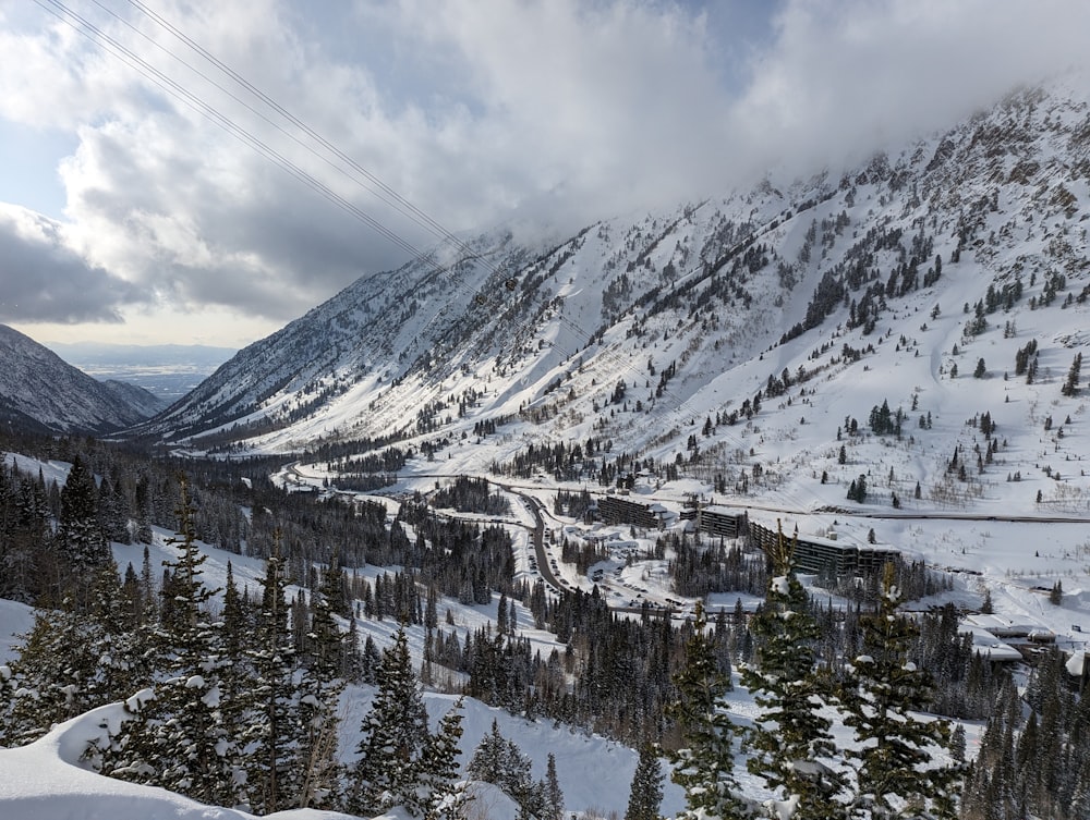 a view of a snowy mountain with a ski lift in the distance