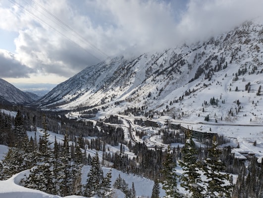 Winter view down Little Cottonwood Canyon with the road threading between deep snowbanks and steep walls