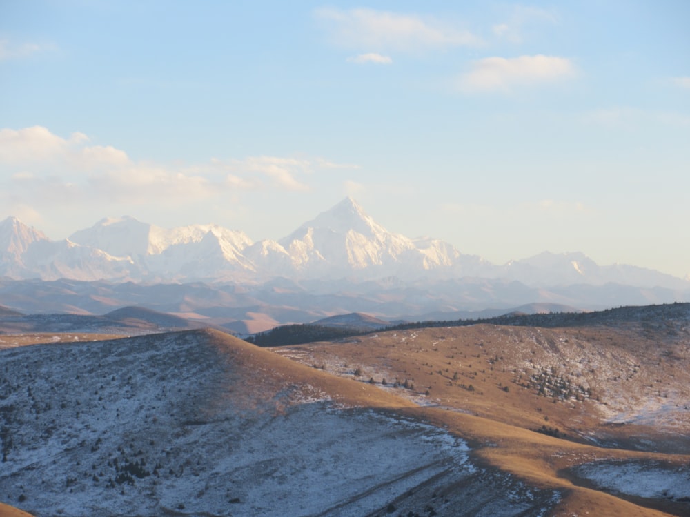 a mountain range with snow covered mountains in the distance
