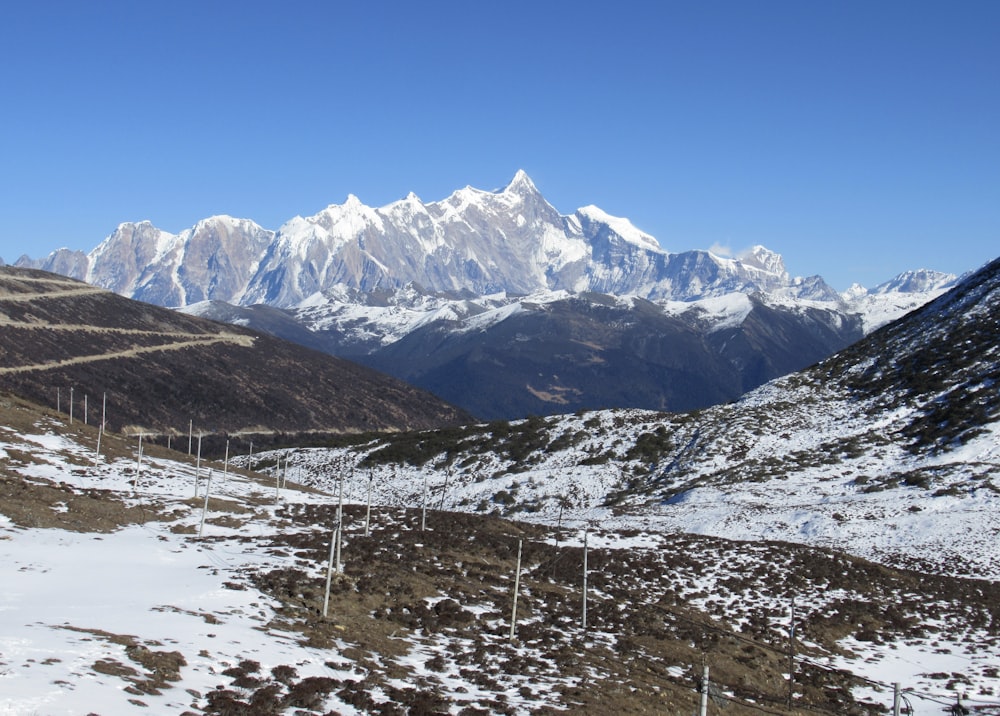 a snow covered mountain range with a telephone pole in the foreground