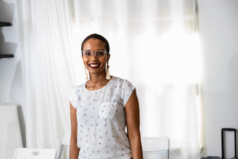 a woman standing in front of a window smiling