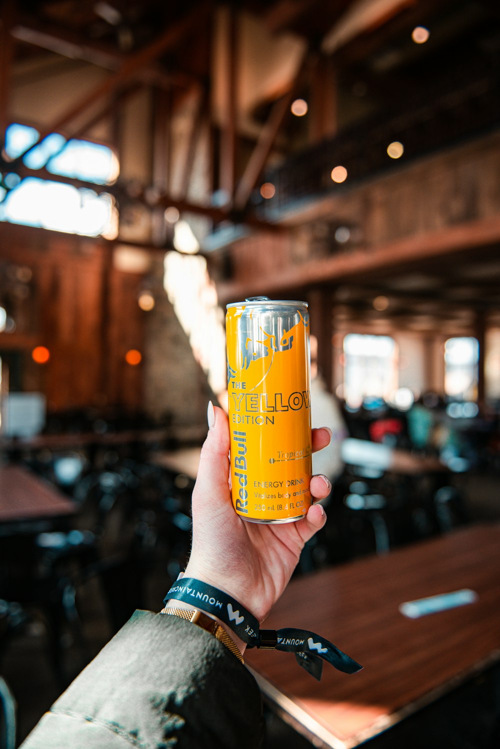 a person holding up a can of orange juice