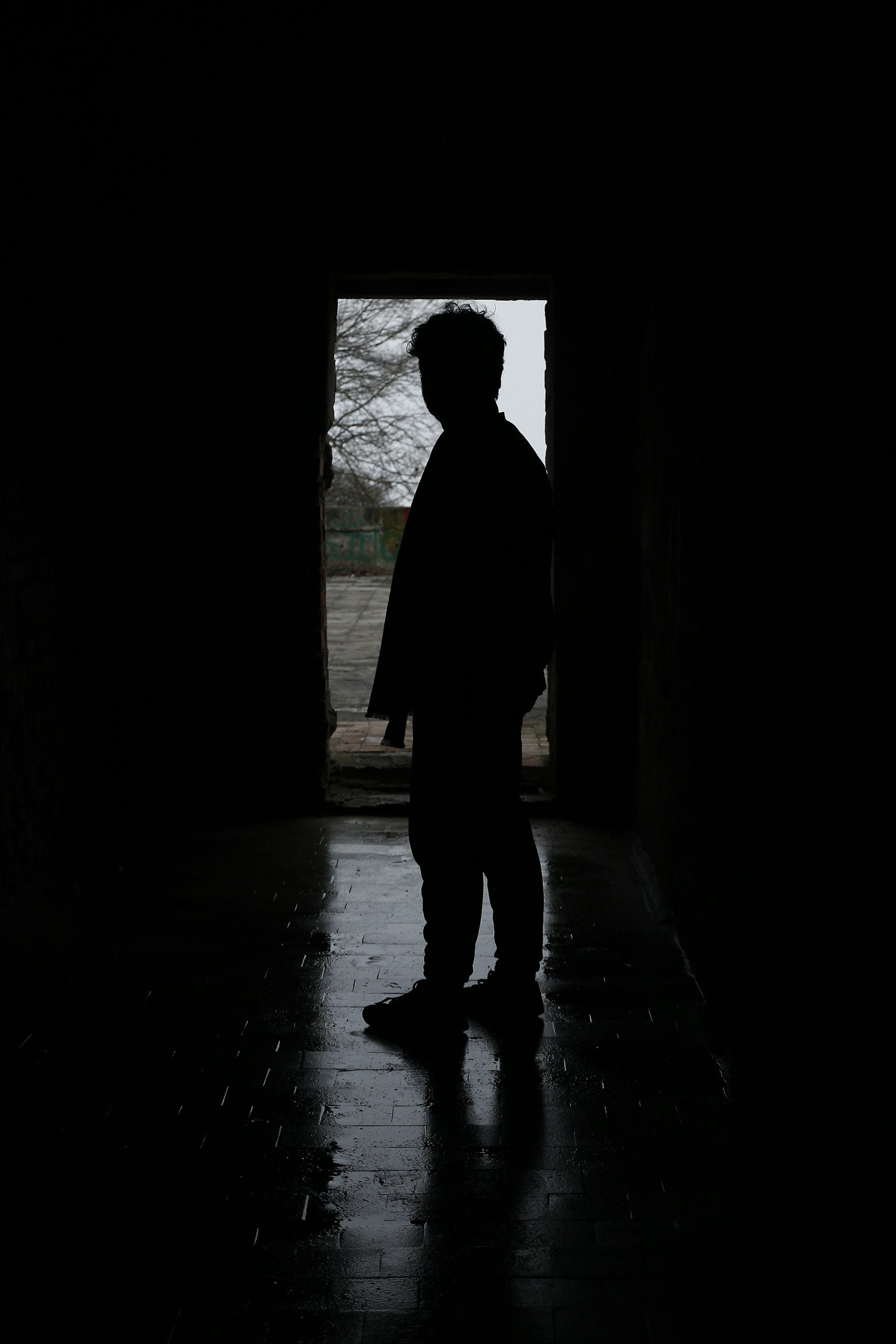 a silhouette of a person standing in a dark tunnel