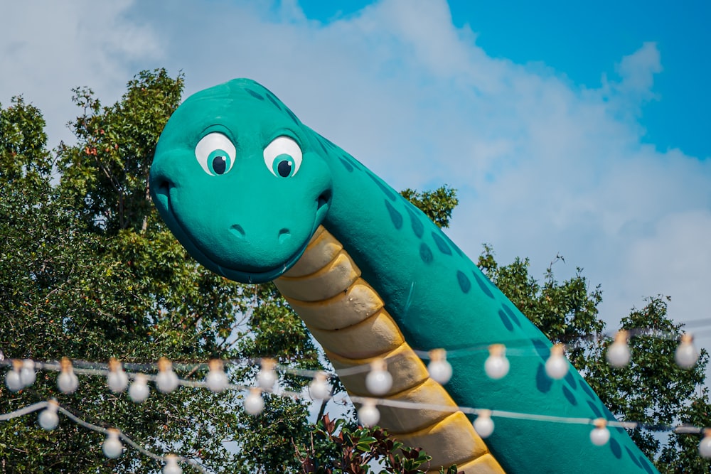 a large inflatable dinosaur with eyes on a string
