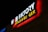 A brightly lit sign for a wings and burger restaurant, with bold white, red, and yellow letters against a dark background.