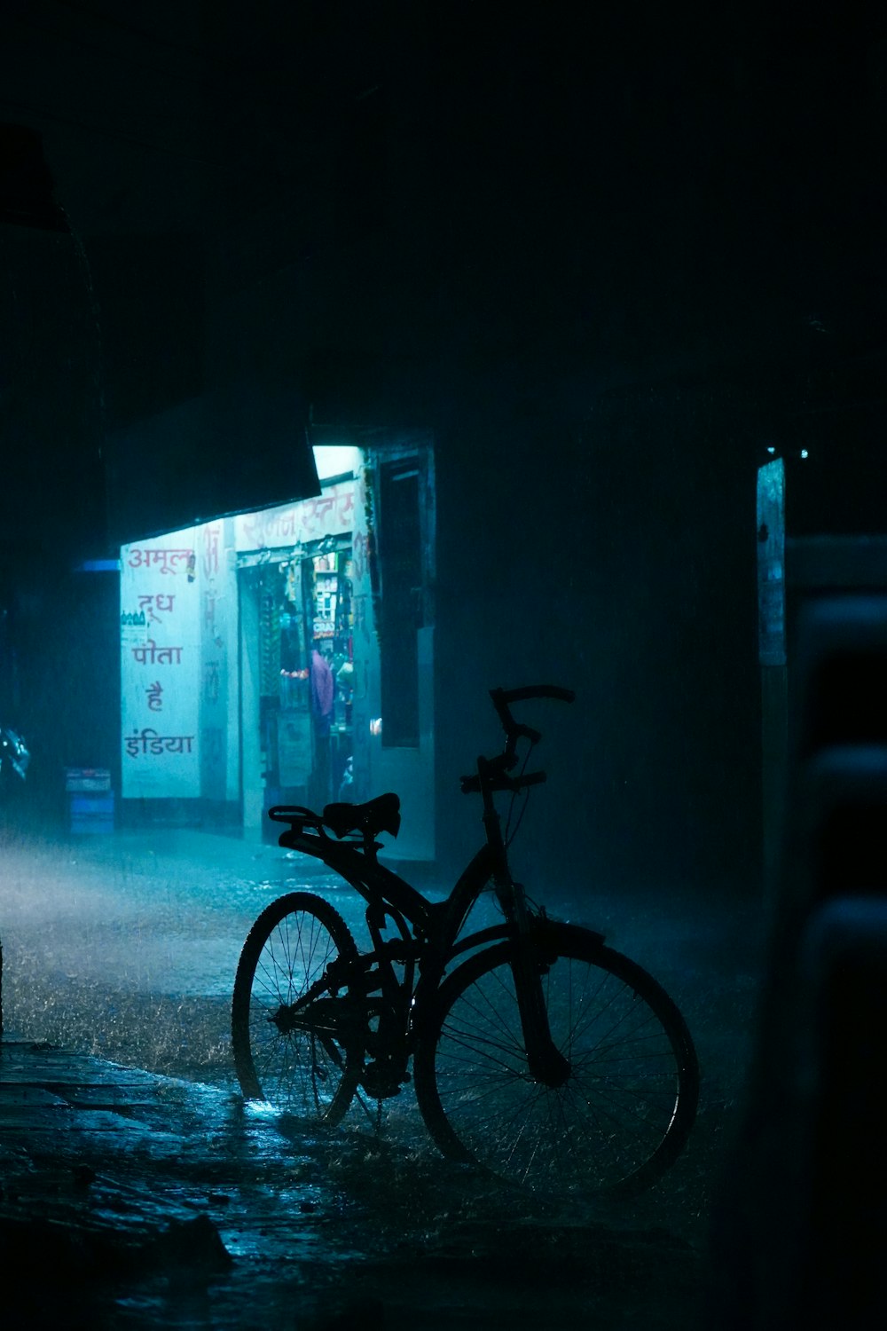a bicycle is parked in the rain at night