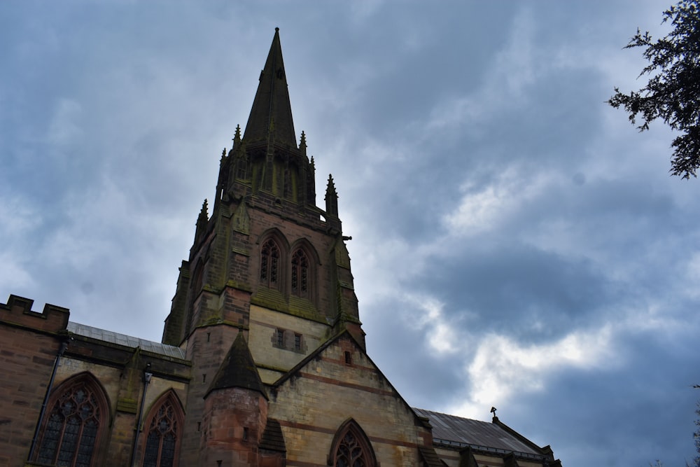 a church steeple with a cloudy sky in the background