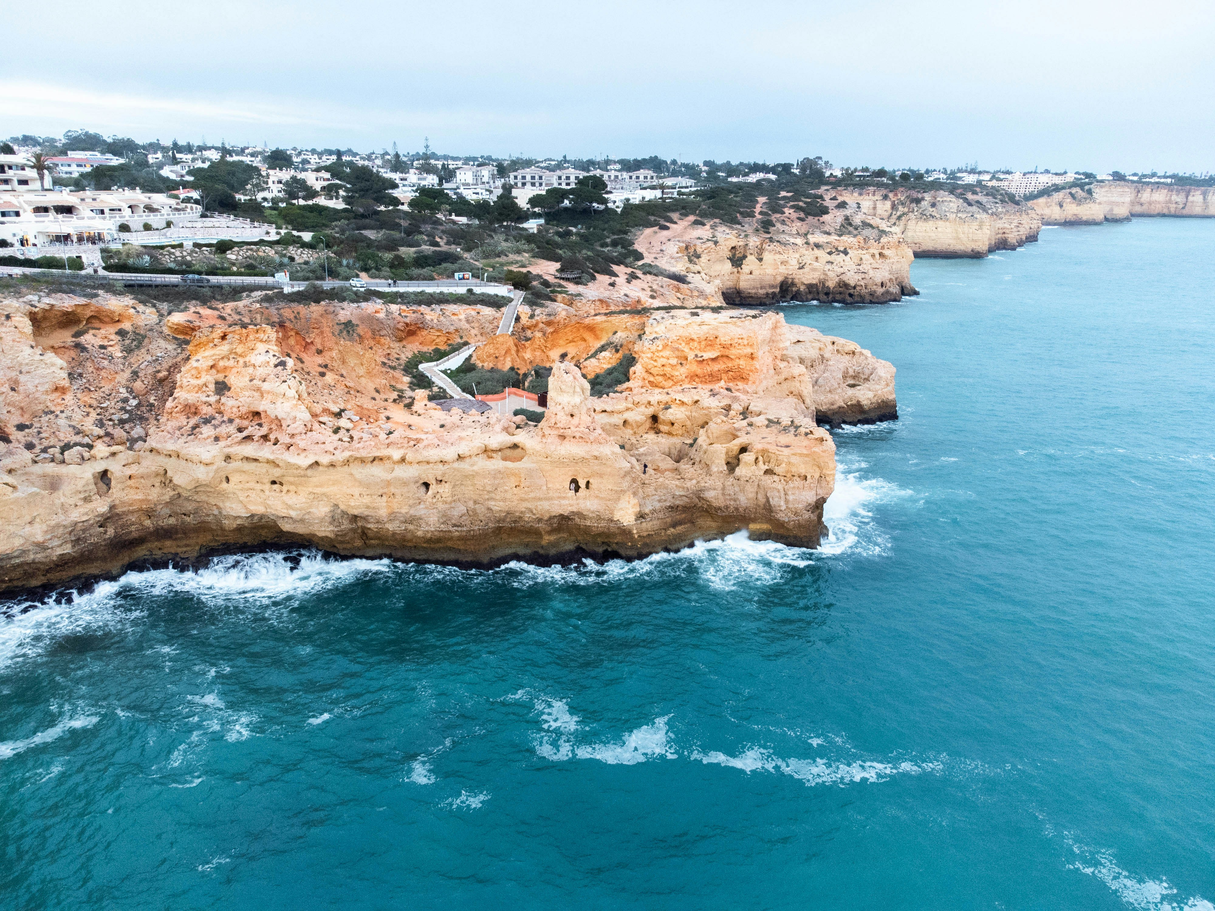 an aerial view of a rocky coastline near a city