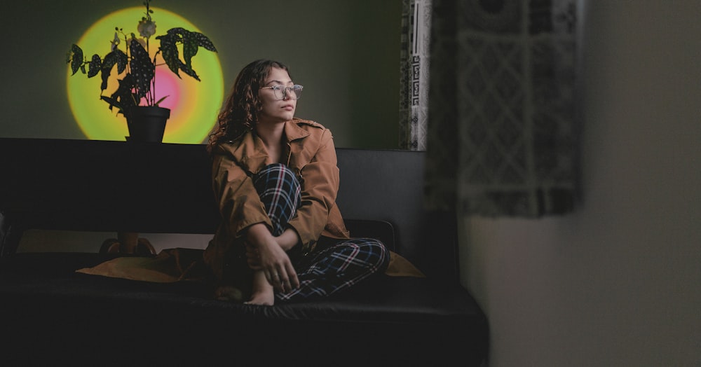 a woman sitting on a couch in front of a painting