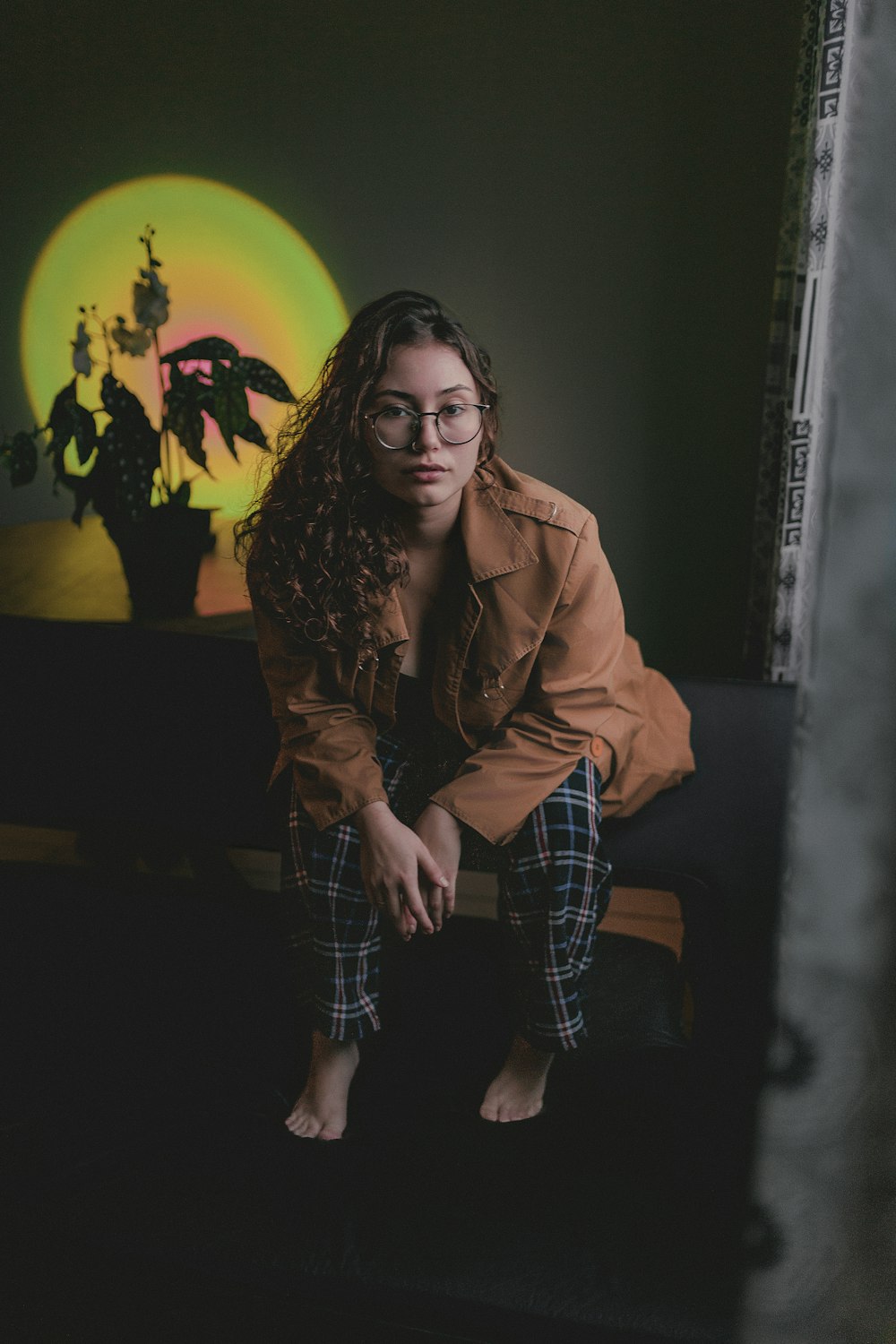 a woman sitting on a couch in front of a painting