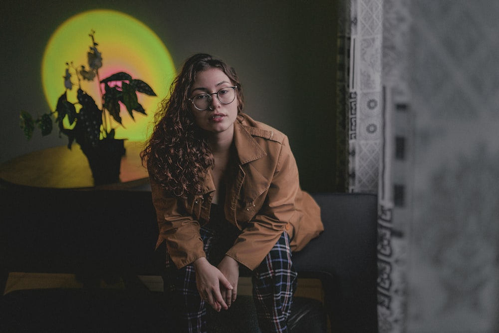 a woman sitting on a couch in front of a painting