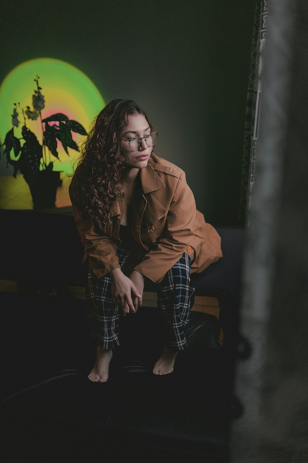 a woman sitting on a couch in front of a painting