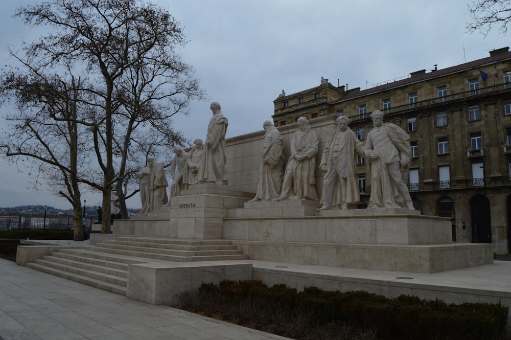 a statue of a group of people in front of a building