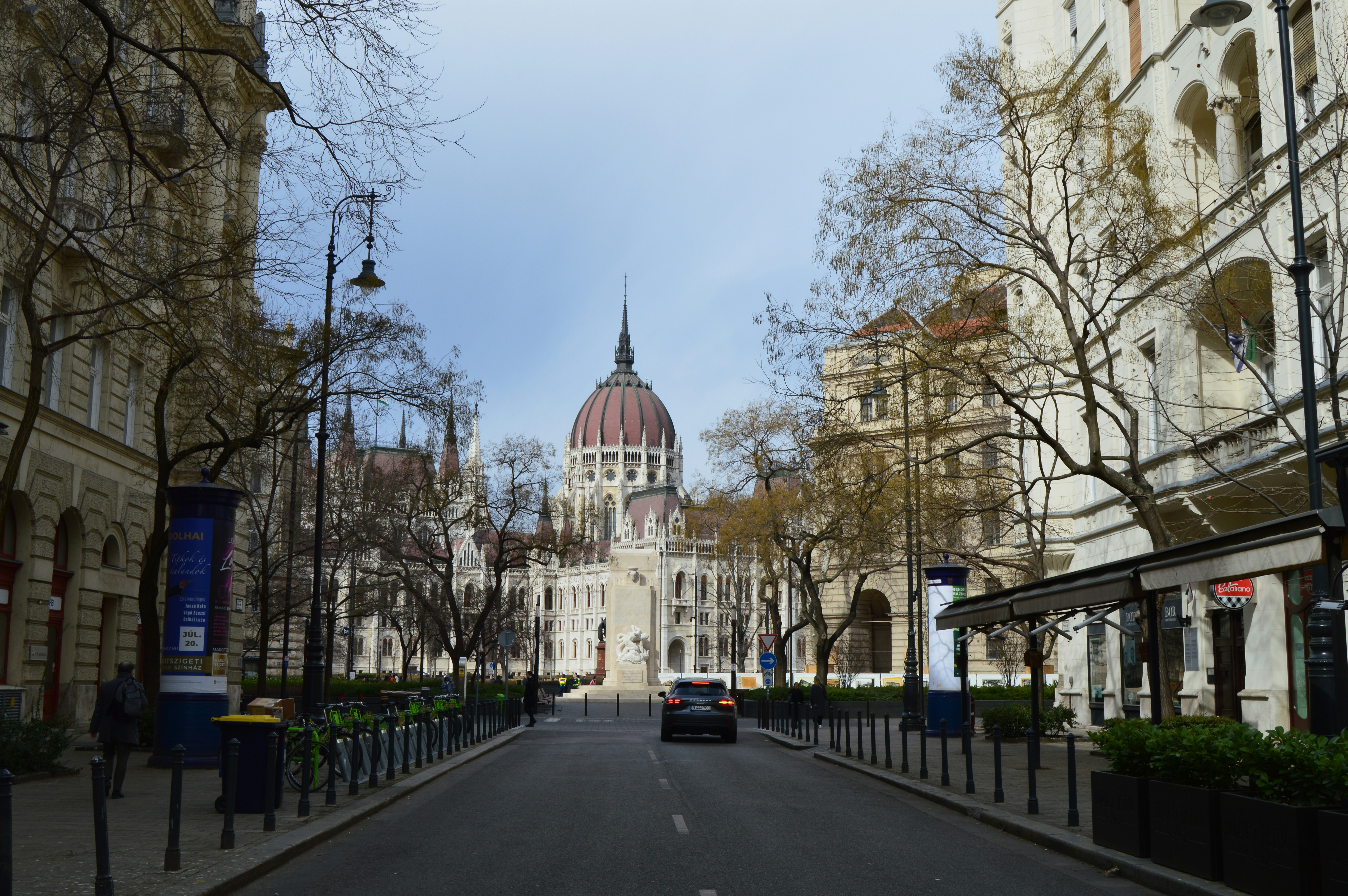 a car driving down a street next to tall buildings