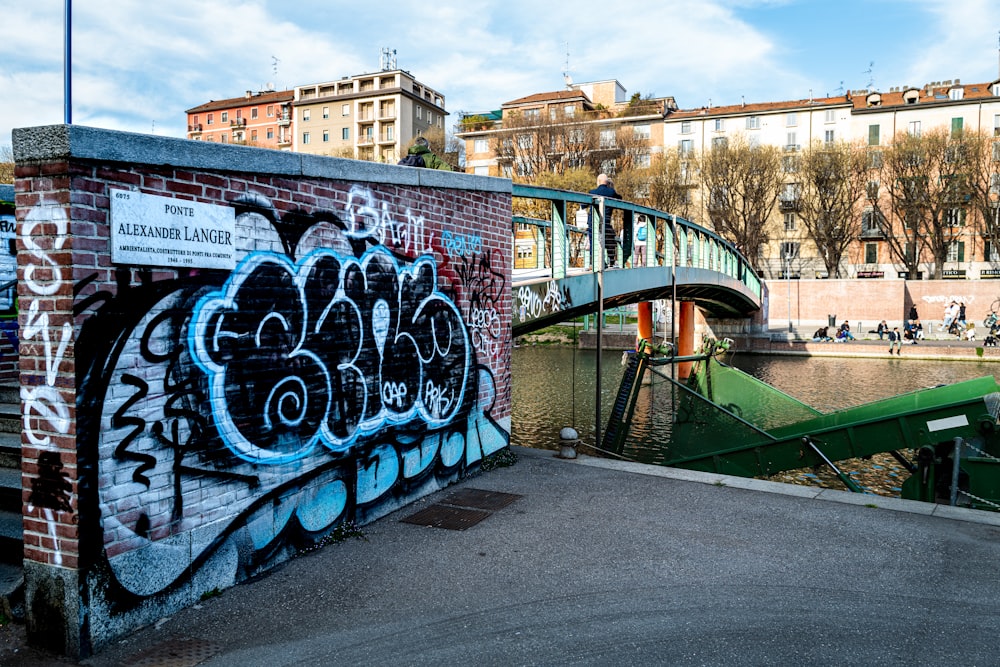 a bridge over a body of water with graffiti on it