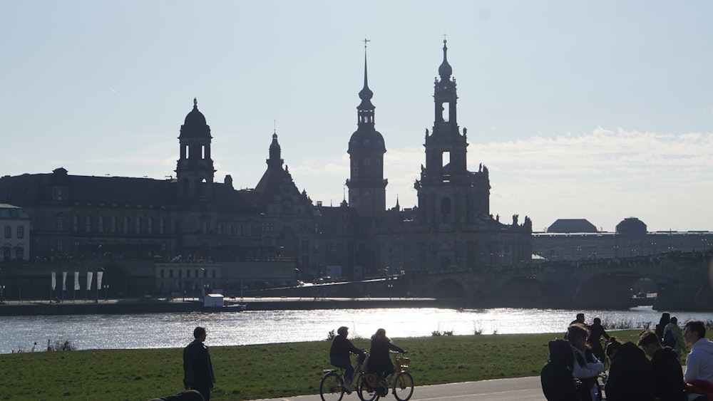 a group of people riding bikes next to a body of water