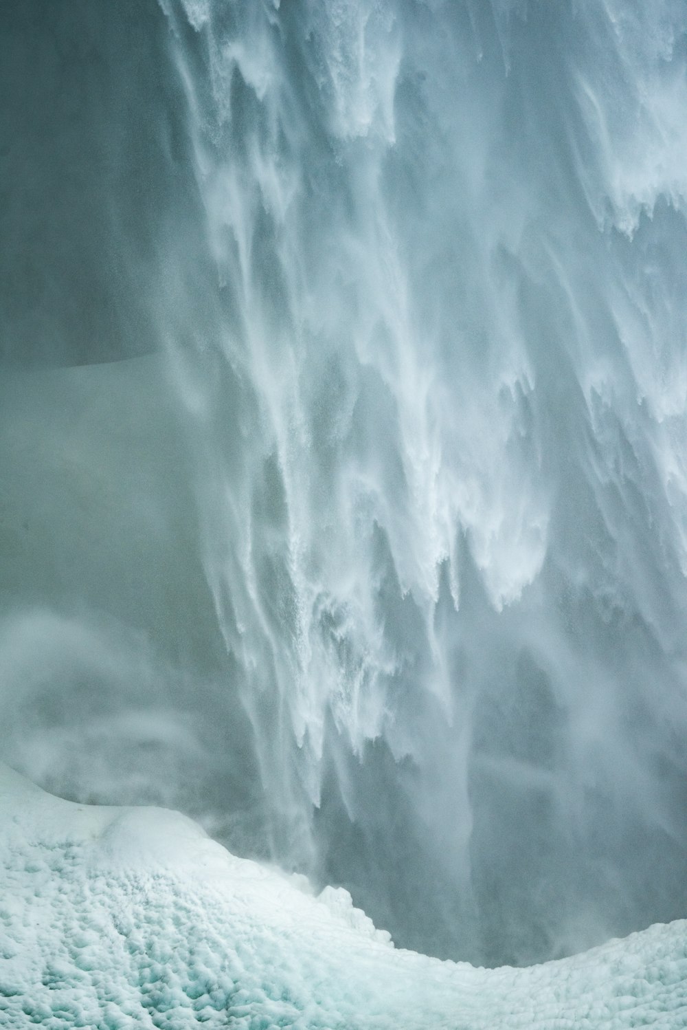 Un homme debout devant une immense cascade