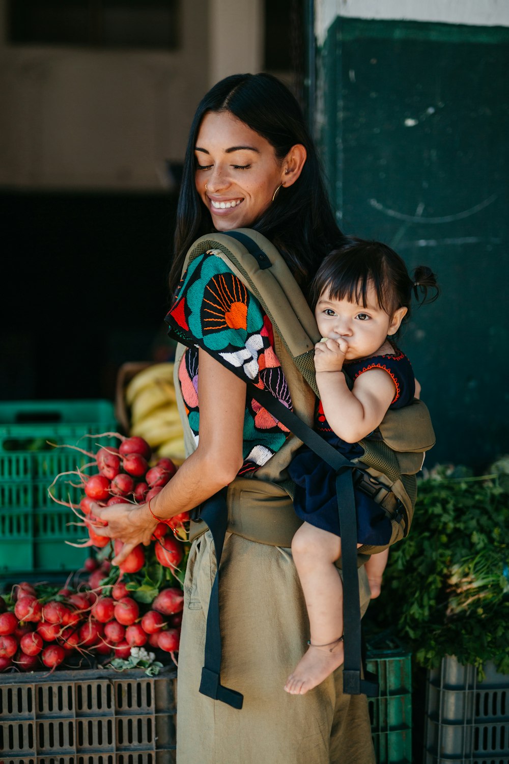 a woman carrying a child in a baby carrier