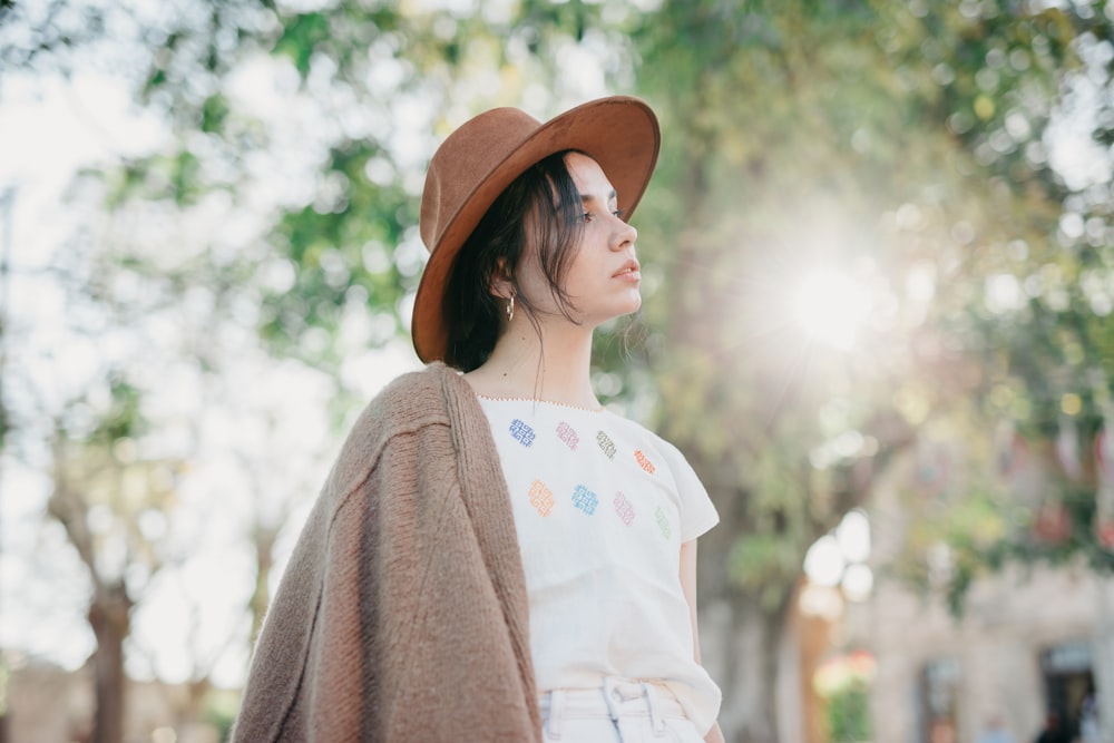 a woman wearing a brown hat and a white shirt