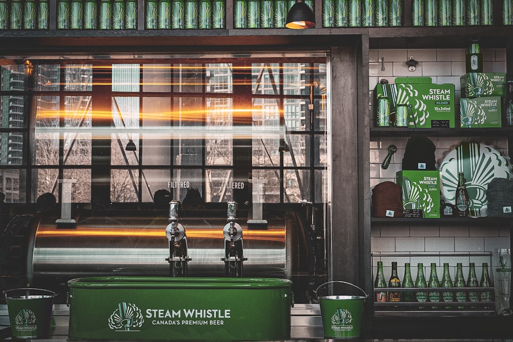 Un frente de tienda con un refrigerador verde y botellas