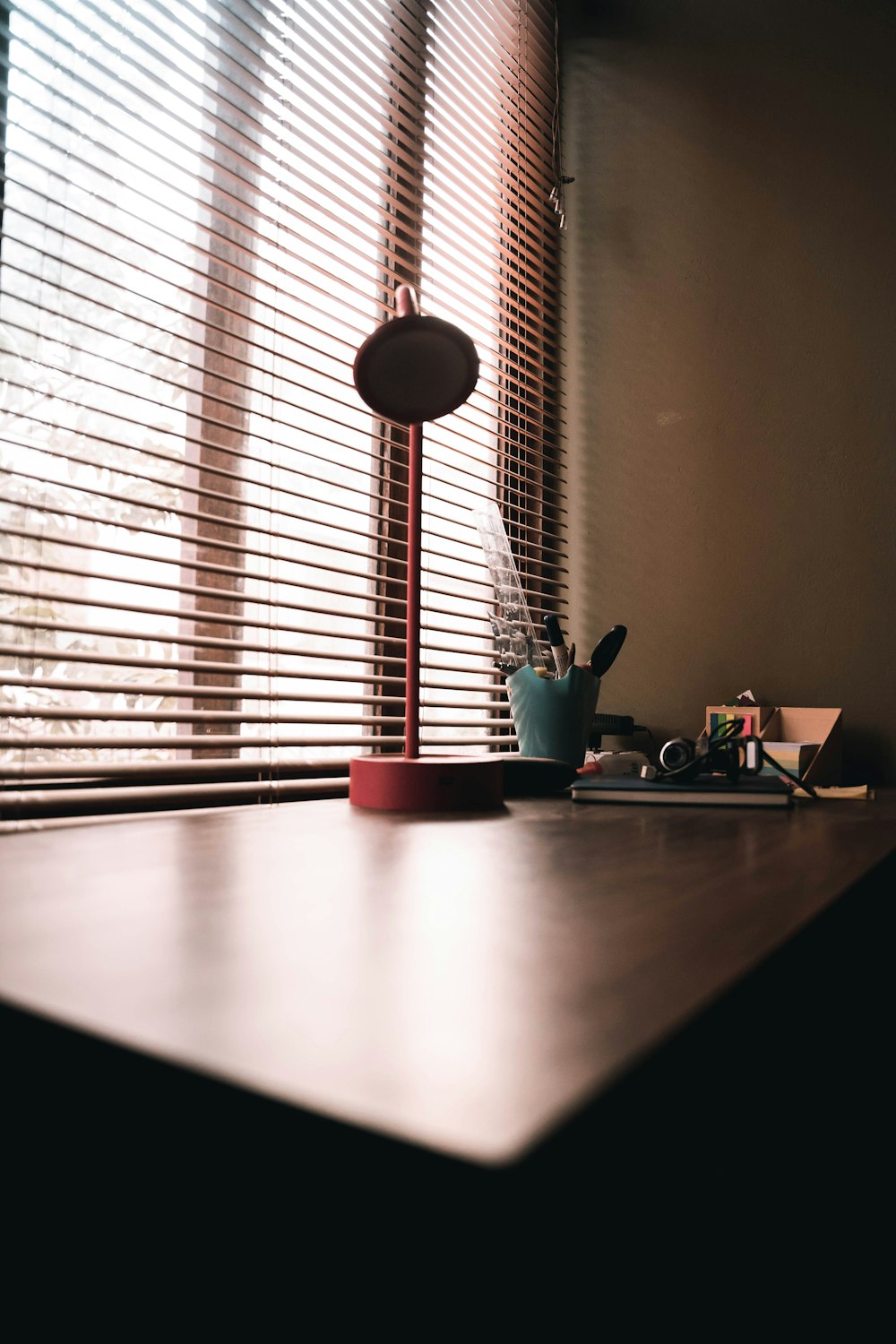 a desk with a lamp and a cup on it