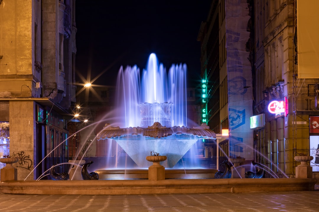 a fountain in the middle of a city at night