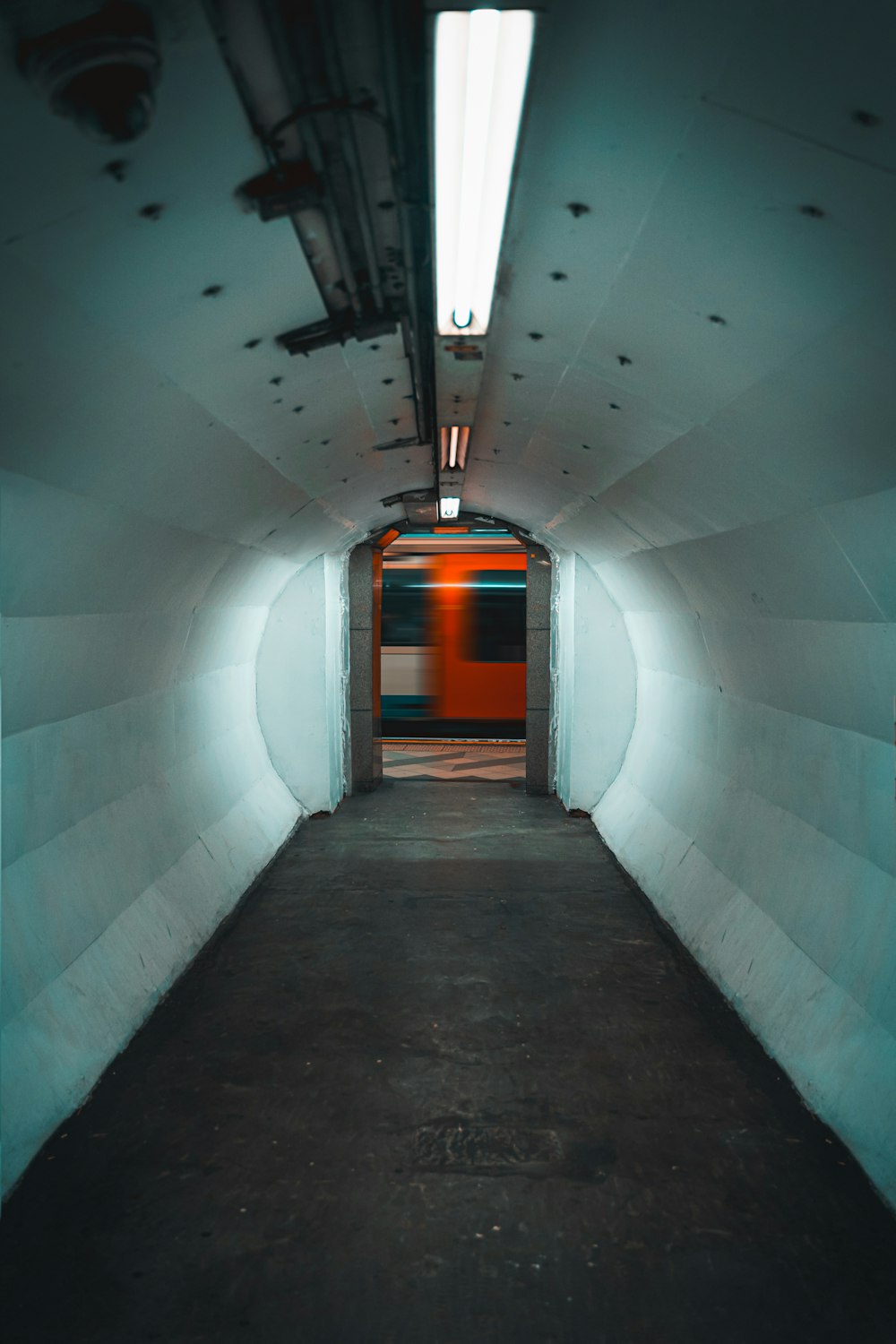 a long tunnel with a red door in it