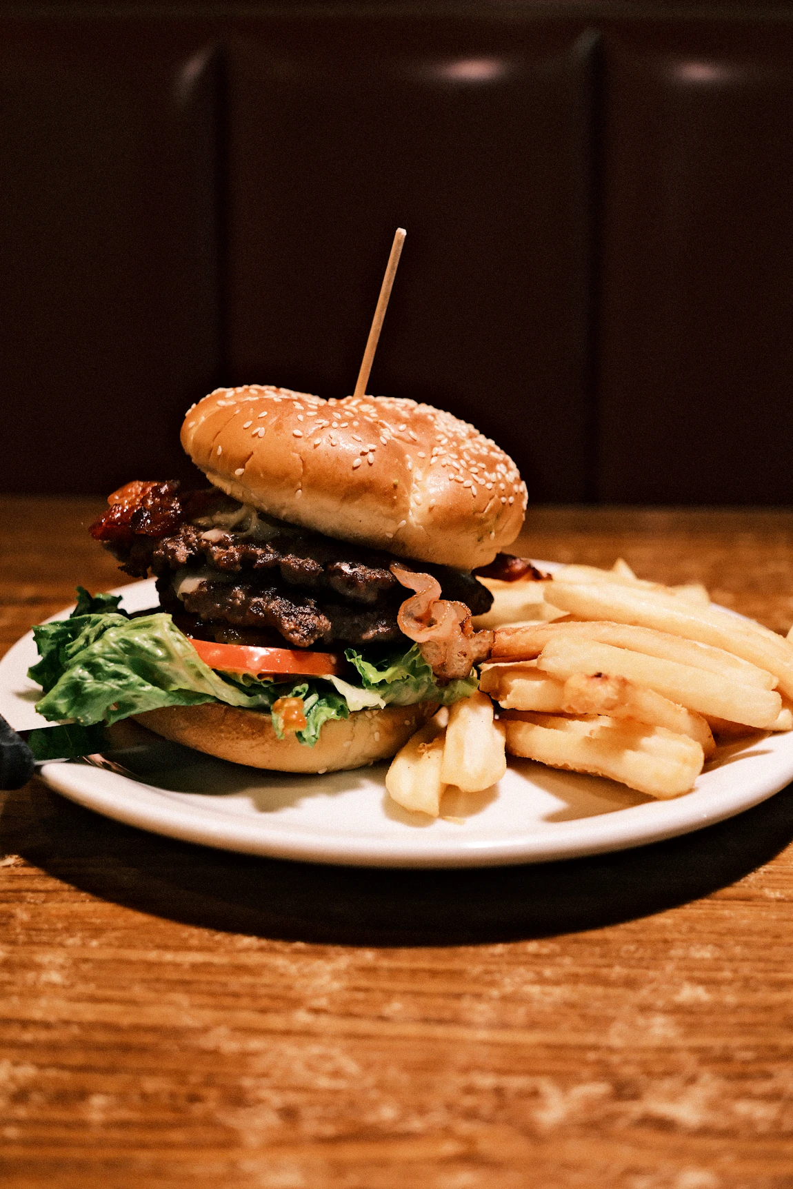 Hamburguesa y papas servidas en restaurante, fotografía real de referencia