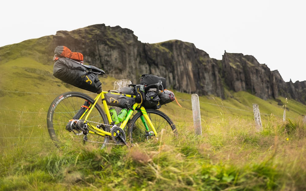 a yellow bike with a backpack strapped to the back of it