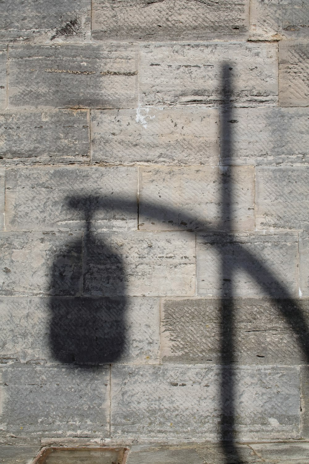 a shadow of a street light on a brick wall