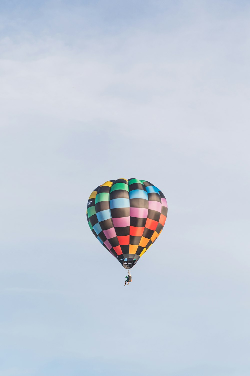 a colorful hot air balloon flying through a blue sky