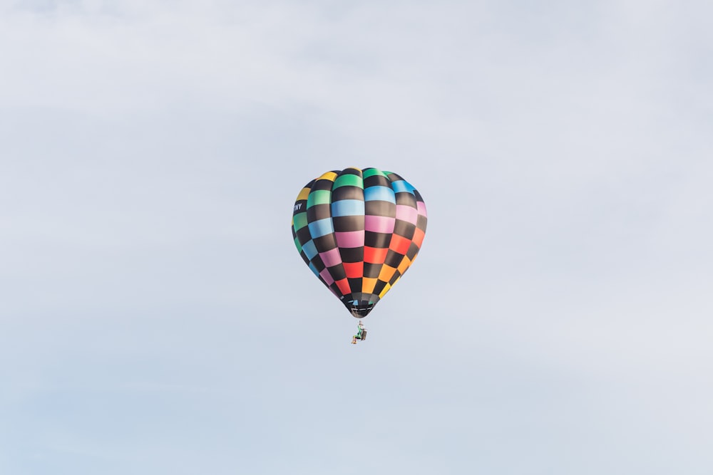 a multicolored hot air balloon flying in the sky