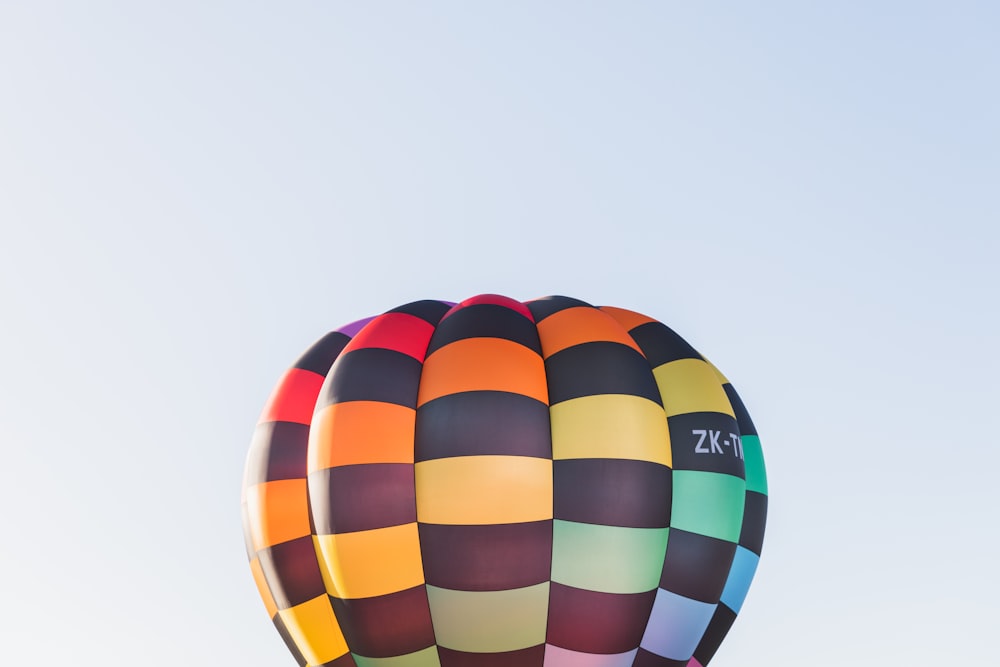 a multicolored hot air balloon flying in the sky