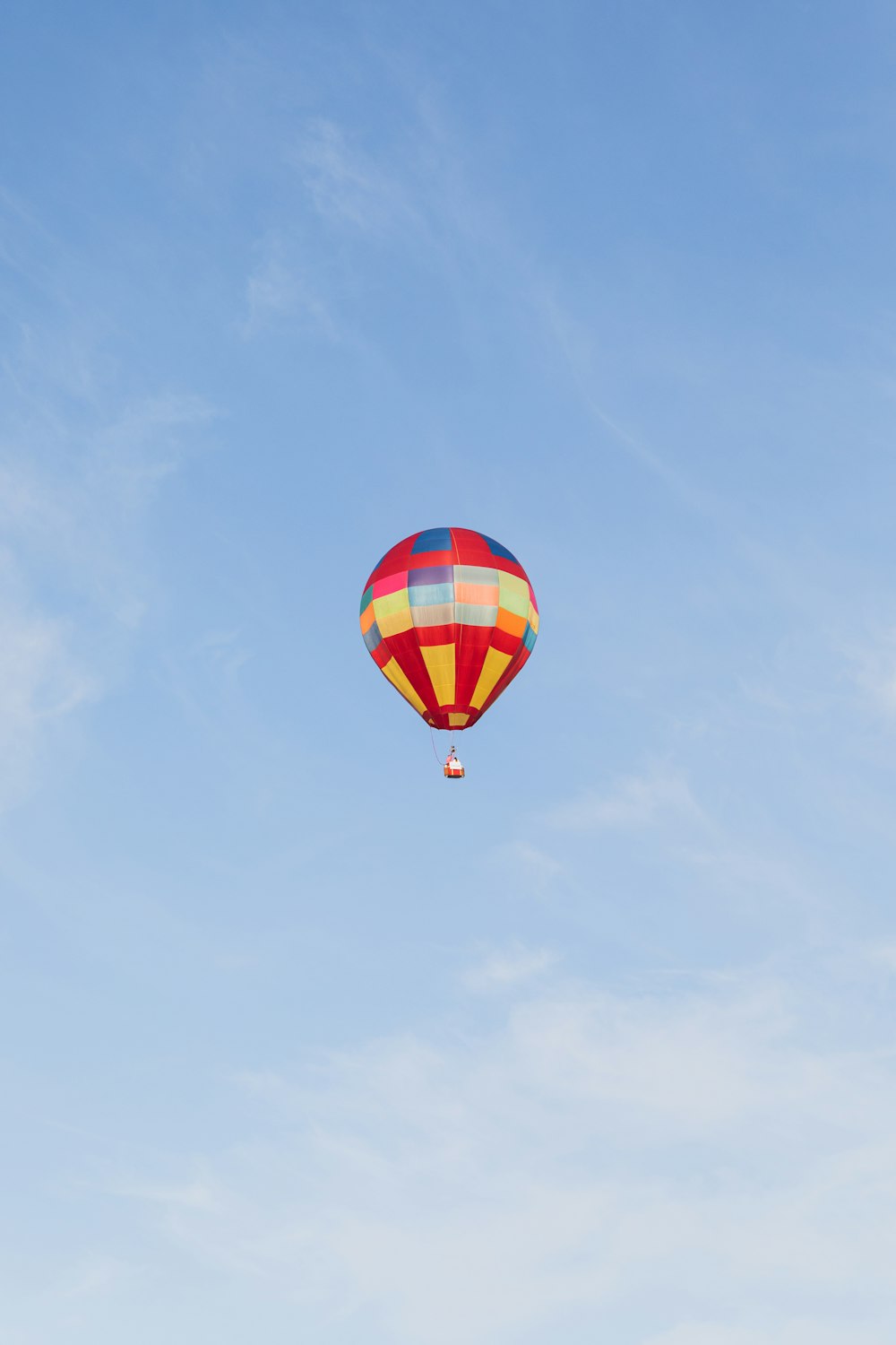 a colorful hot air balloon flying through a blue sky