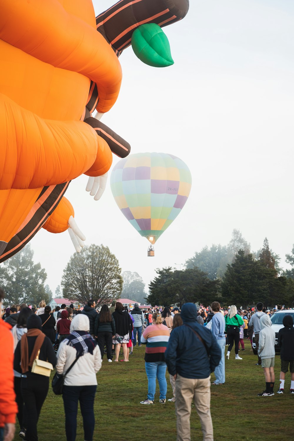 Un grupo de personas de pie alrededor de un montón de globos aerostáticos