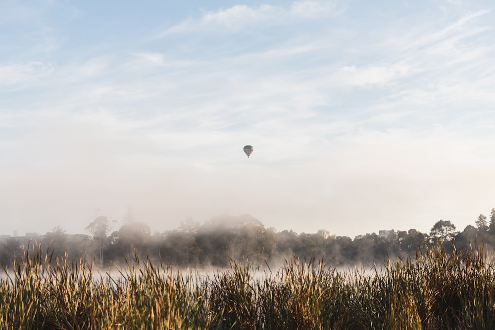 a hot air balloon flying over a lake