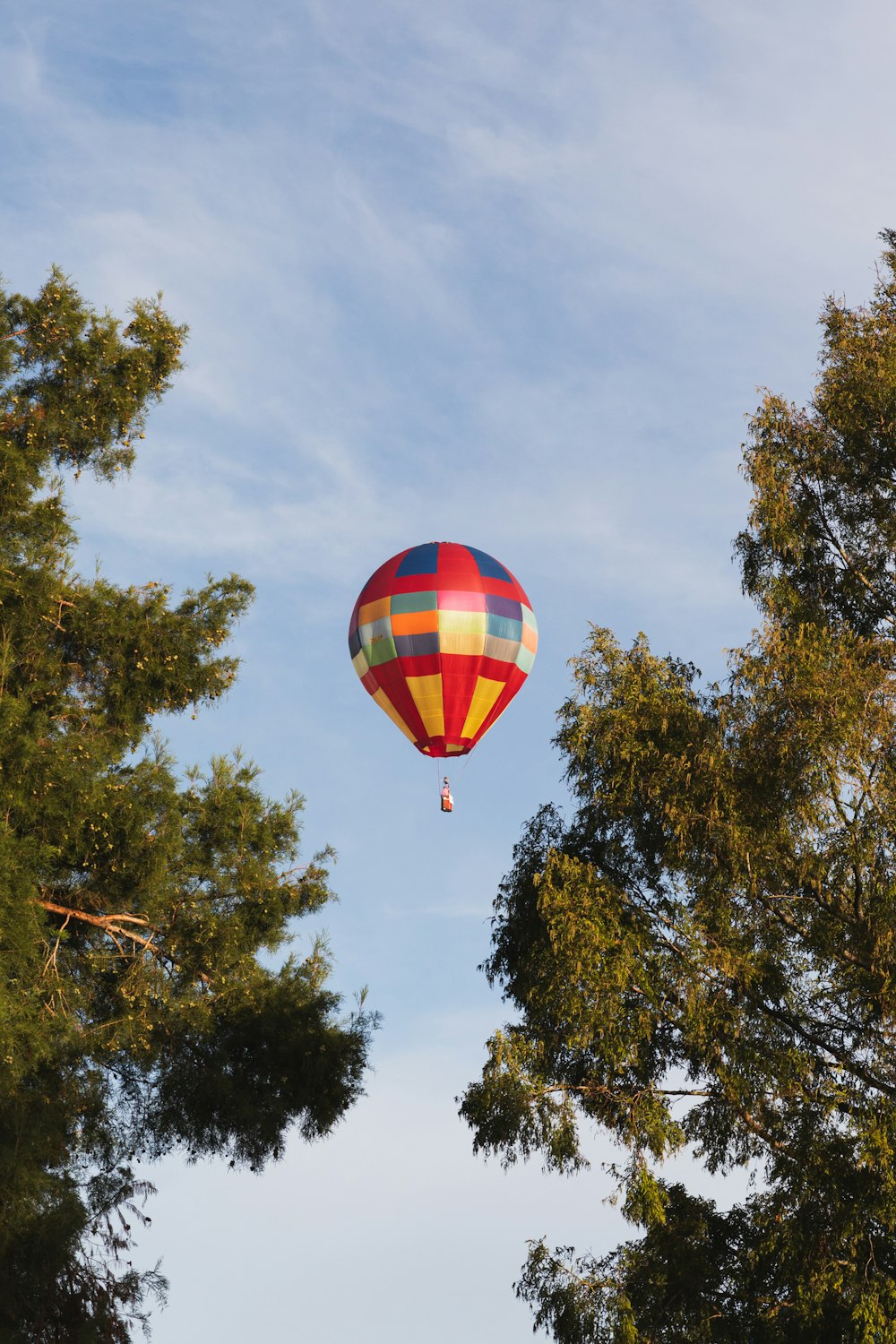 a colorful hot air balloon flying through a blue sky