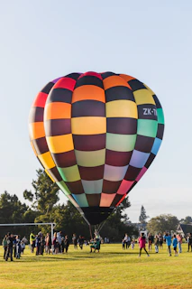 a group of people standing around a large hot air balloon