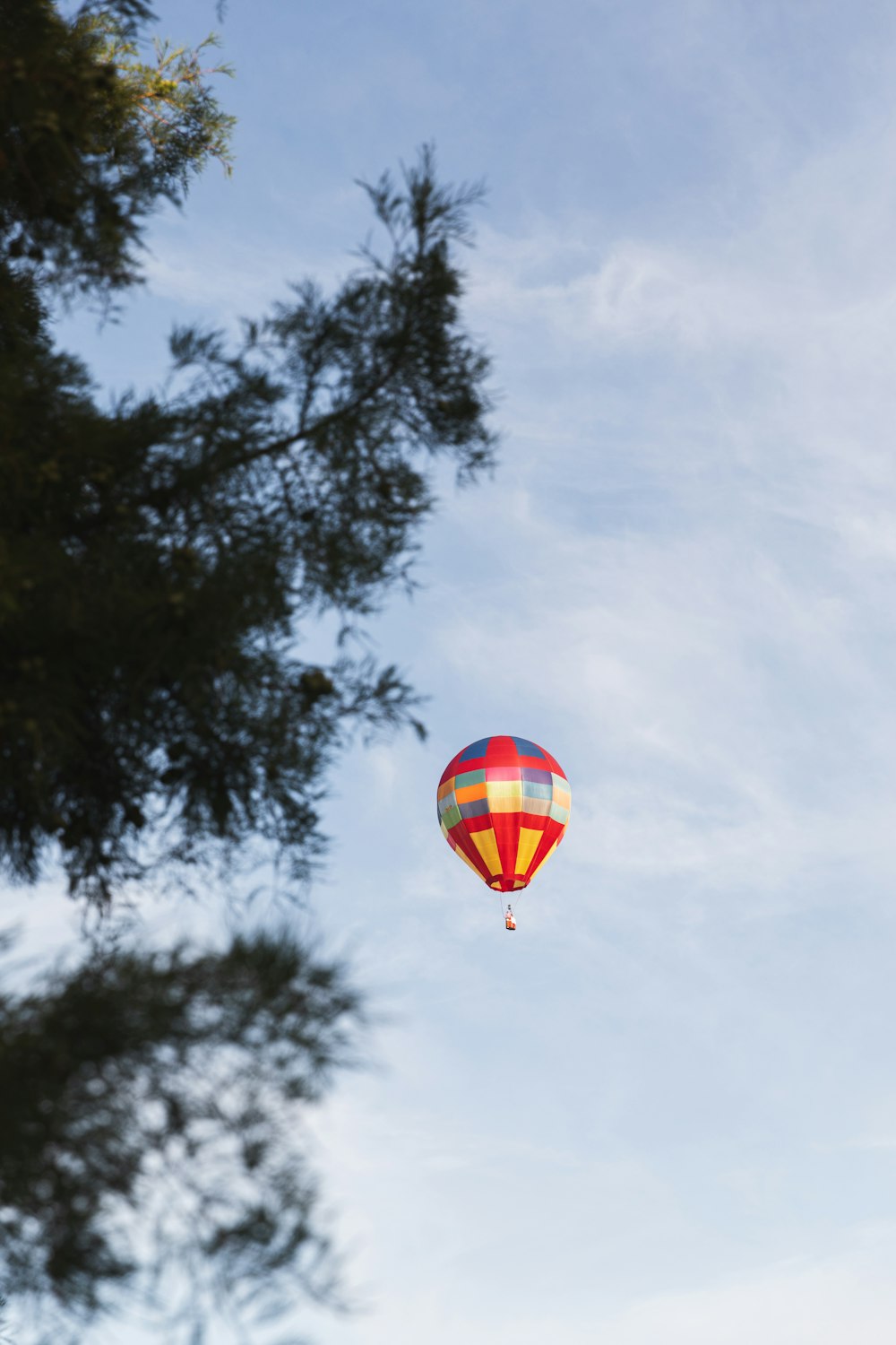 a hot air balloon flying through a blue sky