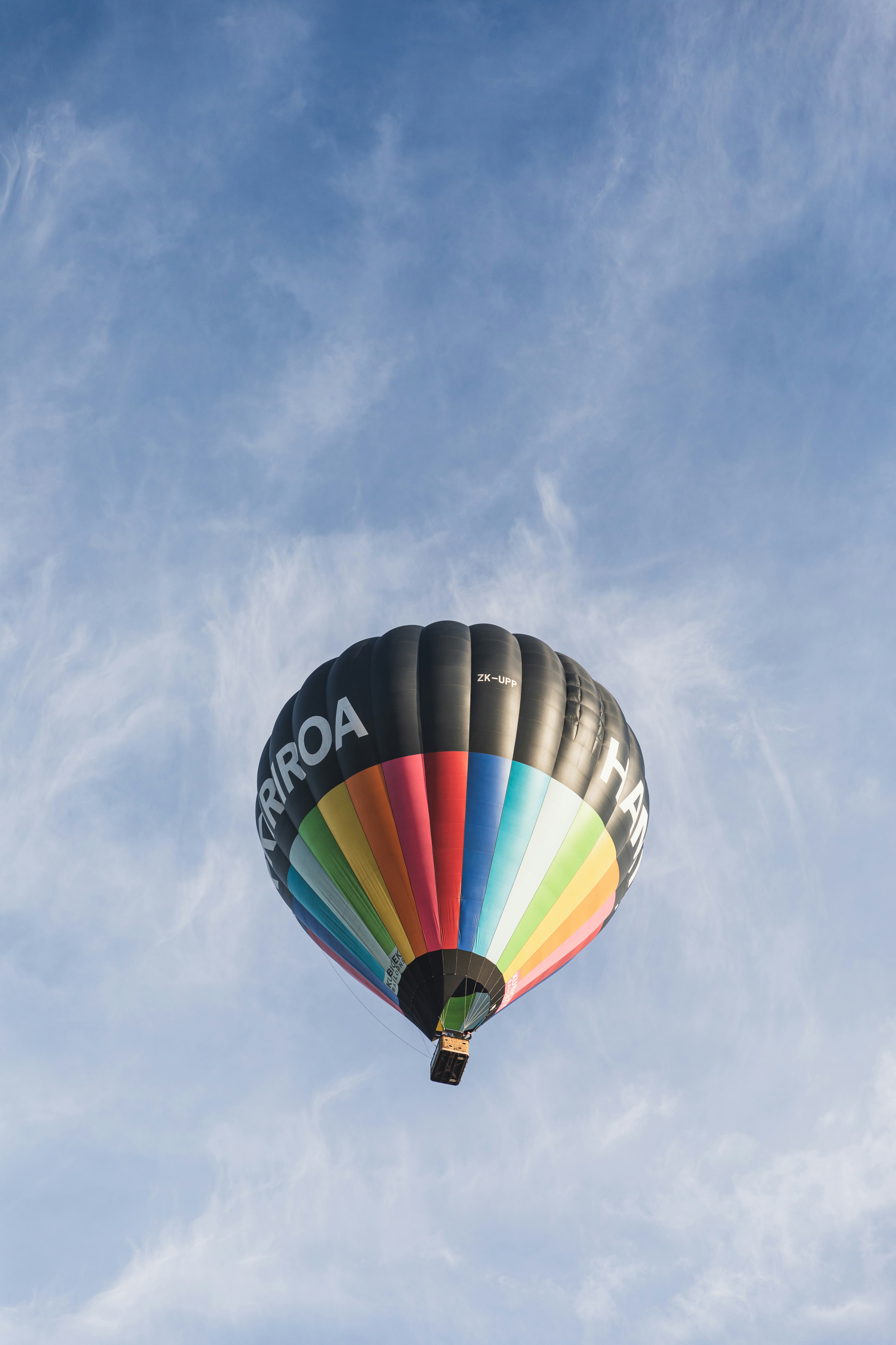 A colorful hot air balloon flying through a blue sky photo – Free Lake ...