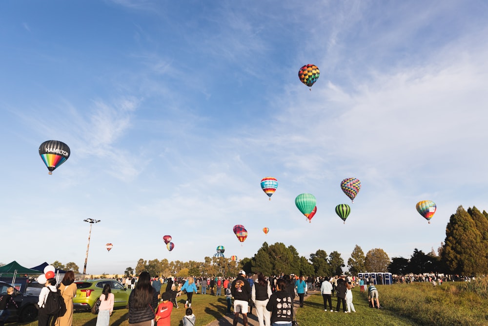 空で熱気球を見ている人々のグループ