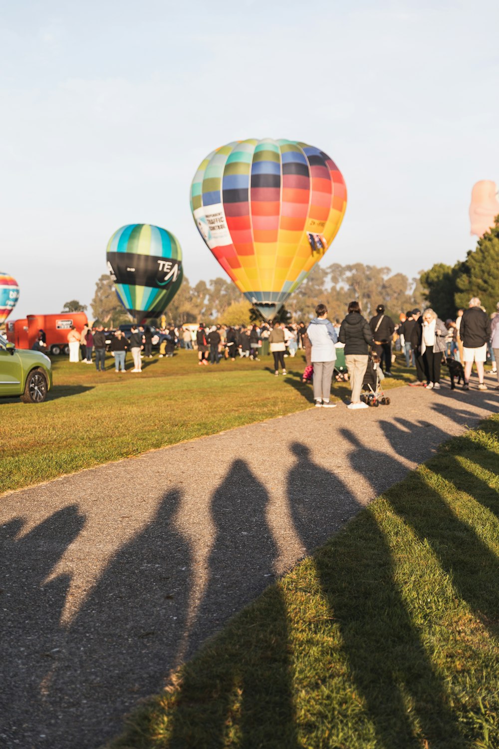 a group of people standing around hot air balloons