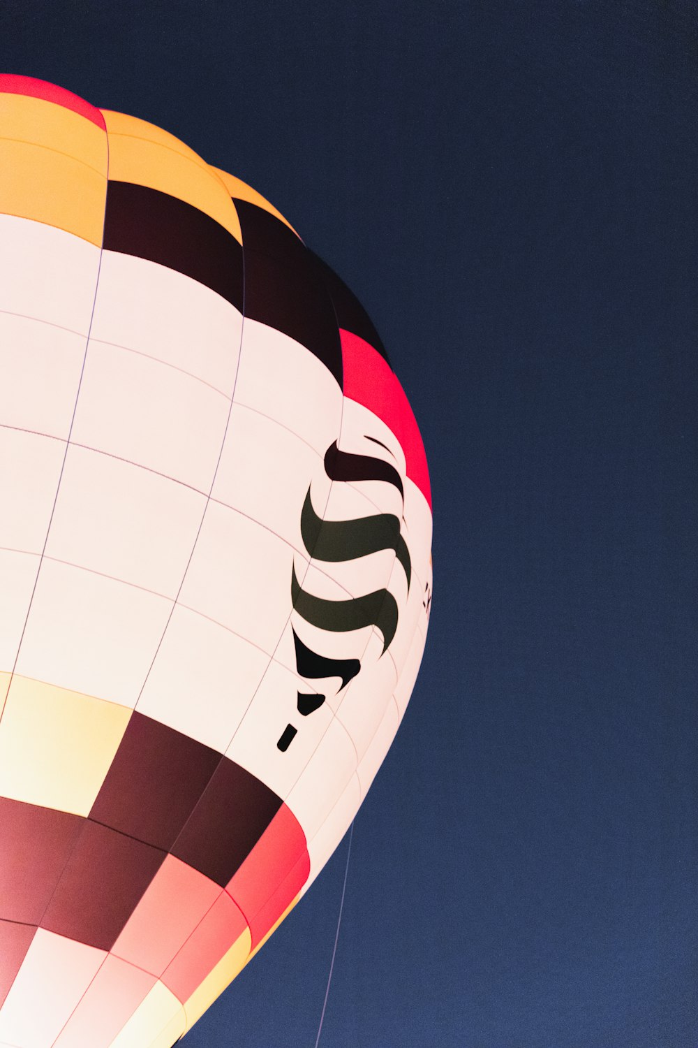 a colorful hot air balloon flying through a blue sky